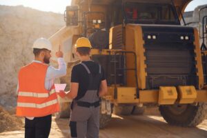Operators talking by large construction machinery